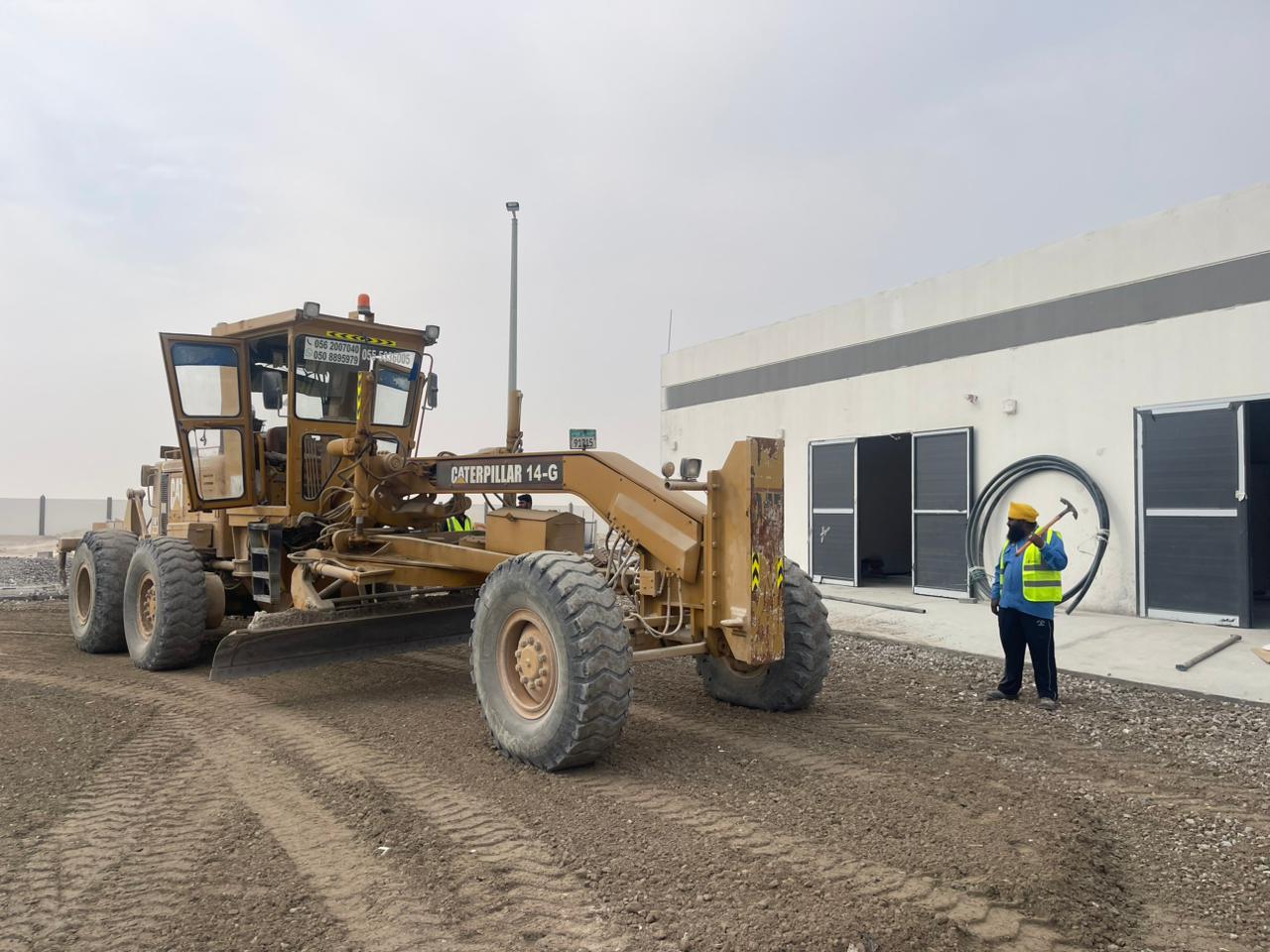 Score Construct grader beside project buildings